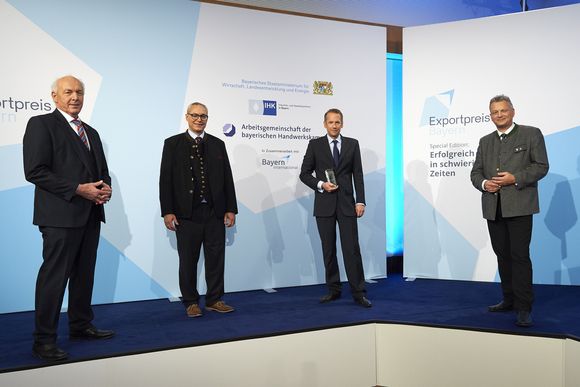 Dr. Valentin Kahl, Dr. Roman Zantl (ibidi GmbH, Mitte) mit Roland Weigert (Staatssekretär im StMWi, rechts) und Dipl.-Ing. Franz Xaver Peteranderl (Präsident der Arbeitsgemeinschaft der bayerischen Handwerkskammern, links)